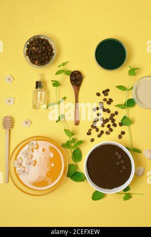 ingredienti naturali biologici: sale marino, scrub al caffè, miele e spazzola per il corpo duro su sfondo giallo. cura della pelle domestica per la cellulite. concetto di pelle Foto Stock