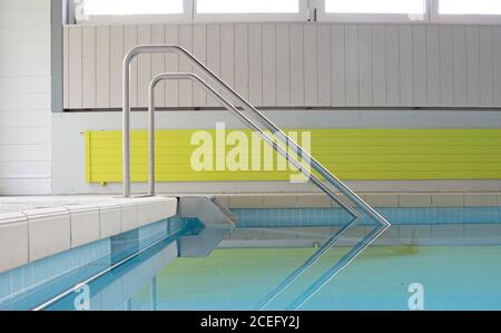 Scale metalliche in una piscina interna Foto Stock