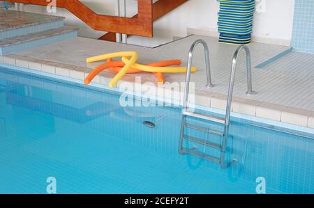 Scale metalliche in una piscina interna Foto Stock
