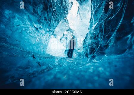 uomo in una bella grotta di ghiaccio blu Foto Stock