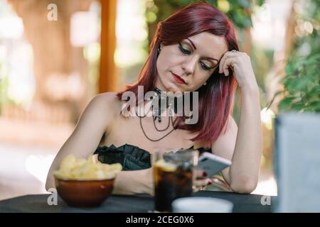 Bella ragazza dai capelli rossi con telefono cellulare. Foto Stock