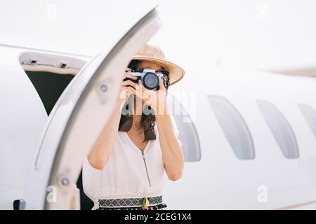 Pretty Woman abbassa un aeroplano all'aperto e scatta foto. Foto Stock