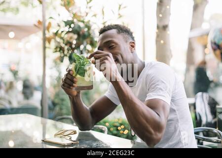 Uomo africano che beve una bevanda analcolica estiva. Foto Stock