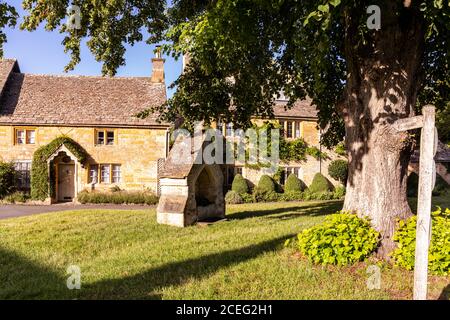 Luce serale su cottage accanto al villaggio verde nel villaggio di Cotswold di Lower Slaughter, Gloucestershire UK Foto Stock