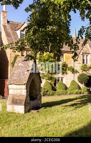 Luce serale su cottage accanto al villaggio verde nel villaggio di Cotswold di Lower Slaughter, Gloucestershire UK Foto Stock