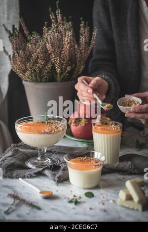 Ritagliare i bicchieri di riempimento a mano con il dessert Foto Stock