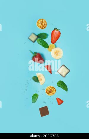 minitola per cereali con fragole fresche, banana, cioccolato, menta di cocco. tendenza all'autoisolamento. levitazione di minuscoli pancake Foto Stock