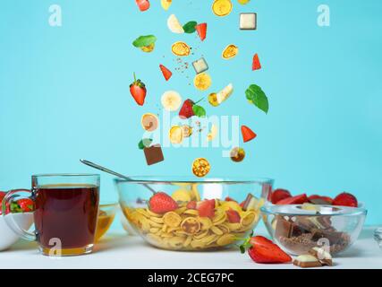 minitola per cereali con fragole fresche, banana, cioccolato, menta di cocco. tendenza all'autoisolamento. levitazione di minuscoli pancake Foto Stock