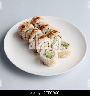 Brioso e delizioso sushi giapponese con salmone in pesce volante il caviale si trova splendidamente su un piatto bianco su sfondo bianco da sopra Foto Stock