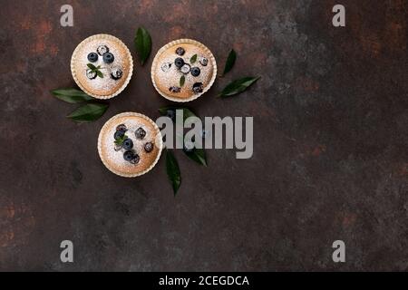 Muffin al mirtillo vista dall'alto marrone piatto con sfondo in legno spazio di copia Foto Stock