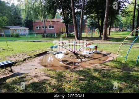 Giostra sul parco giochi in un primo piano puddle Foto Stock