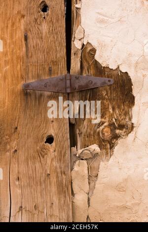 Cerniera arrugginita sulla porta di legno intemperie di un edificio derelitto nella città fantasma virtuale di Thompson Springs, Utah Foto Stock