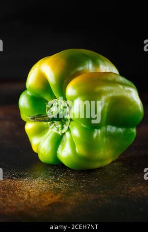 Peperone verde dolce su fondo scuro. Peperone verde giallo fresco (capsicum) Foto Stock