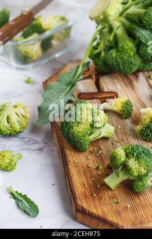 Broccoli verdi freschi su un tagliere di legno. Macro foto verde verdure fresche broccoli. Verdure verdi per la dieta e l'alimentazione sana. Cibo biologico Foto Stock