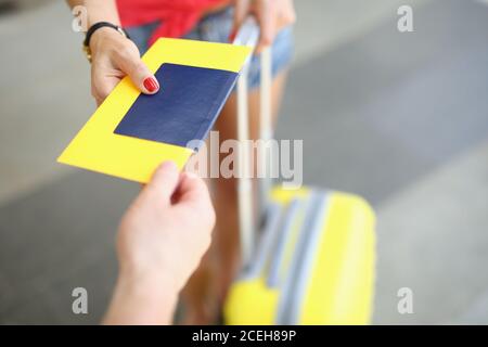 Passaporto e biglietto di mano maschile femminile sullo sfondo di valigia Foto Stock