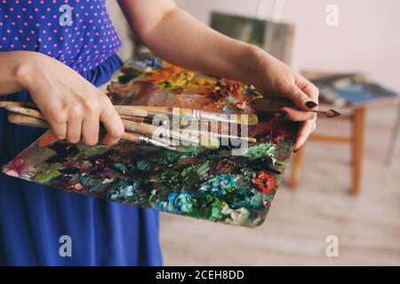 pittori pennelli e vernici ad olio su palette di legno. tavolozza di artisti macro, texture vernici ad olio misto in diversi colori e saturazione. tavolozza con pa Foto Stock