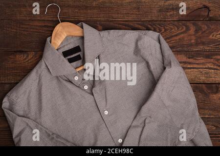 Camicia business classica da uomo con motivo a pied. Abito casual su sfondo marrone grunge di legno Foto Stock
