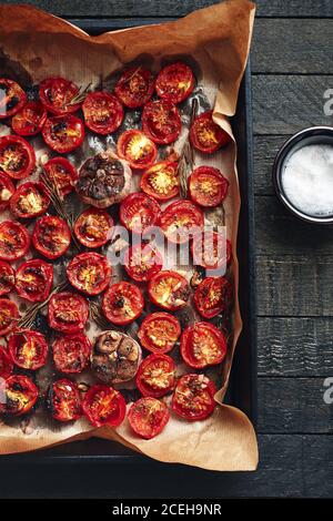 Forno pomodori ciliegini arrostiti su un forno vassoio vista dall'alto. Foto Stock