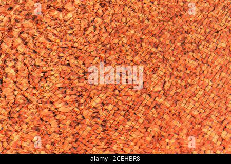 Texture di sfondo astratta arancione. Piscina fondo caustica ondulazione e flusso con onde sfondo texture Foto Stock