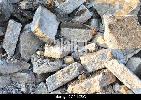 Pezzi rotti di asfalto ad un luogo di costruzione. Riciclaggio e riutilizzo di macerie di calcestruzzo frantumato, asfalto, materiale da costruzione, blocchi. Frantumato сoncrete Bac Foto Stock