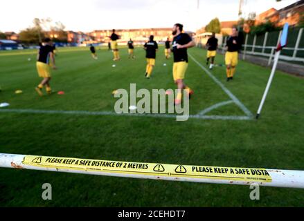 Una visione generale dei giocatori che si riscaldano con adesivi che consigliano di prendere le distanze sociali per evitare la diffusione del coronavirus prima della partita preliminare di fa Cup Extra Round a Selhurst Street, Nottingham. Foto Stock