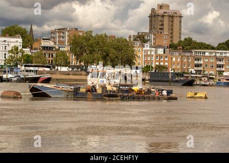 Houseboats si oppone all'architettura di gentrifificazione lungo il fiume Tamigi a Battersea, Greater London, England, United Kingdom, Europe Foto Stock