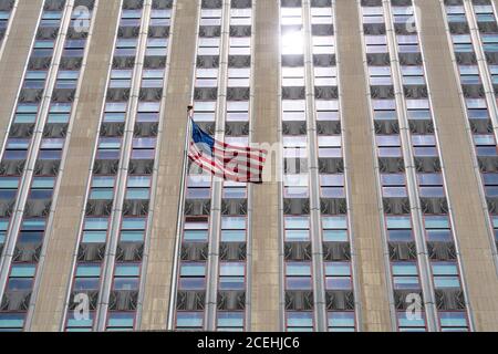 Una bandiera americana scuote di fronte allo Stato dell'Impero Edificio Foto Stock