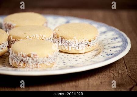 Deliziosi biscotti argentini alfajores con crema dulce de leche primo piano isolato. Amaretti bianchi alla vaniglia su sfondo bianco. Francese delicato dess Foto Stock