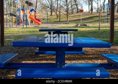 Un banco blu di metallo quadrato in un parco sotto a Gazebo in legno Foto Stock