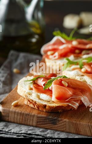 Tradizionale antipasto di prosciutto crudo di parma. Bruschetta con prosciutto di Parma e parmigiano. Piccoli panini con prosciutto, parmigiano, aru fresco Foto Stock