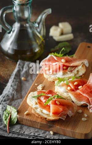 Tradizionale antipasto di prosciutto crudo di parma. Bruschetta con prosciutto di Parma e parmigiano. Piccoli panini con prosciutto, parmigiano, aru fresco Foto Stock