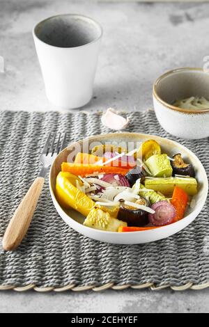 Frittura mista di verdure con parmigiano. Le verdure arrostite mescolano sul piatto con le posate sul tappeto di vimini, cibo sopra. Offerta stagionale Foto Stock