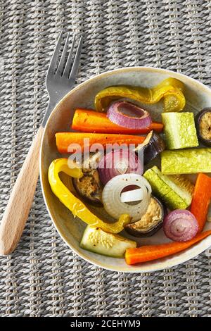 Frittura mista di verdure con parmigiano. Le verdure arrostite mescolano sul piatto con le posate sul tappeto di vimini, cibo sopra. Offerta stagionale Foto Stock