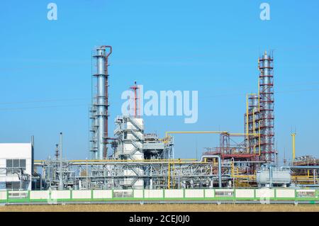 Impianto di trattamento del gas. Tubi di alimentazione e torri di raffineria industriale della fabbrica di gas naturale sul cielo blu di sfondo. Rete di gasdotti naturali. Foto Stock