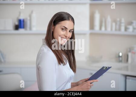 Abbastanza giovane professionista in piedi nella stanza e sembra allegro Foto Stock