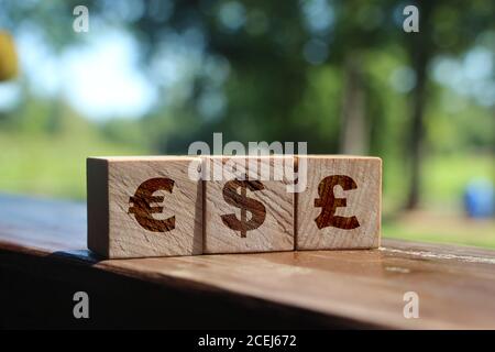 Cubetti di legno con Euro, dollaro USA, Gran Bretagna Pound signs. Concetto di valuta. Foto Stock