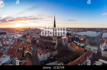 Vista panoramica aerea al centro storico di riga, banchina del fiume Daugava. Famoso punto di riferimento - st. La torre della Chiesa di Pietro e la chiesa della Cattedrale City Dome Foto Stock