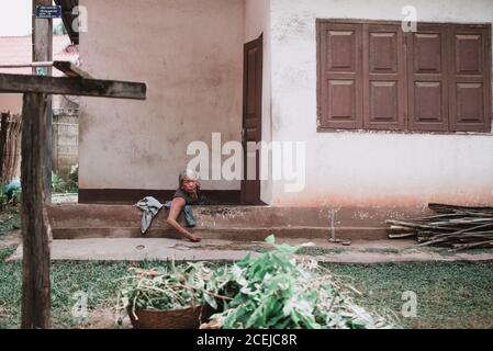 Donna asiatica anziana adulta seduta a casa e guardando la macchina fotografica. Foto Stock