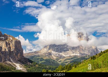Colorata vista dall'alto sul monte Sassolungo tra le nuvole in una giornata estiva soleggiato dal Passo Sella di val Gardena Dolomiti, Alto Adige, Italia Foto Stock