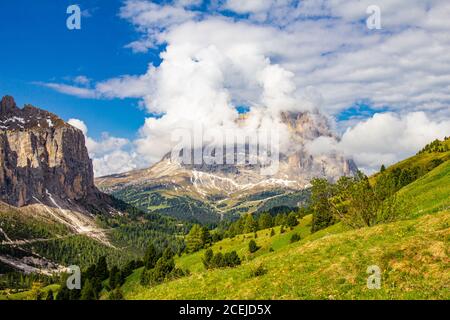 Colorata vista dall'alto sul monte Sassolungo tra le nuvole in una giornata estiva soleggiato dal Passo Sella di val Gardena Dolomiti, Alto Adige, Italia Foto Stock