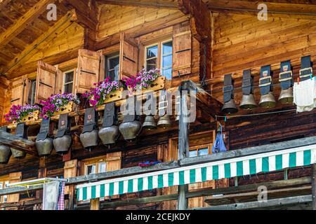 Una collezione di enormi campane è appesa alla casa principale dell'Alpe di Pöris. Da qui il Lenkerhof ottiene il suo formaggio di capra fresco. ALP Lairy, Lenk, Svizzera, Lenk, Svizzera Foto Stock