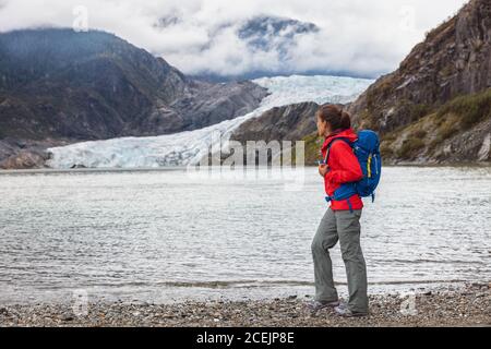 Escursionista turistico a piedi sul sentiero da ghiacciaio Mendenhall, Alaska destinazione escursionistica viaggio vacanza. Donna asiatica trekking in acqua glaciale con ghiaccio Foto Stock