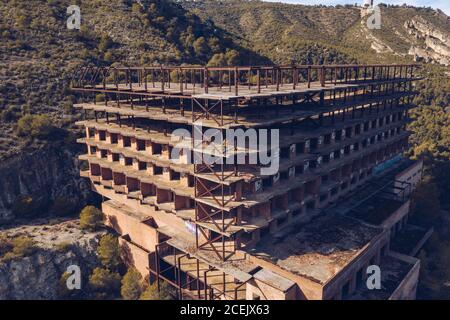 Vista sul drone di un edificio moderno in costruzione situato vicino al pendio di montagna in giornata di sole a Cuenca, Spagna Foto Stock