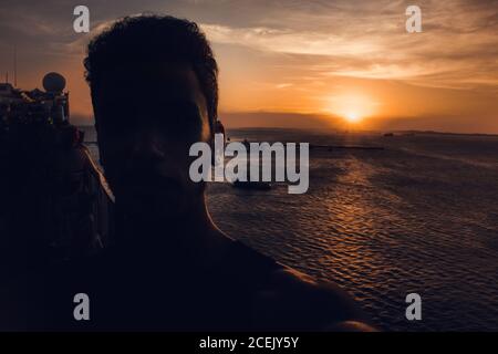 Silhouette di un uomo in crociera al tramonto sul Mare in Brasile Foto Stock