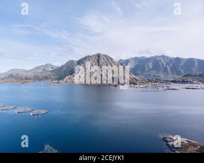 Foto aerea di montagne rocciose sulla costa dell'oceano blu delle isole Lofoten in piena luce del sole, Norvegia Foto Stock