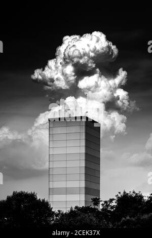 Foto in bianco e nero di una fitta nuvola che galleggia dietro il moderno edificio della torre di Istanbul, Turchia Foto Stock