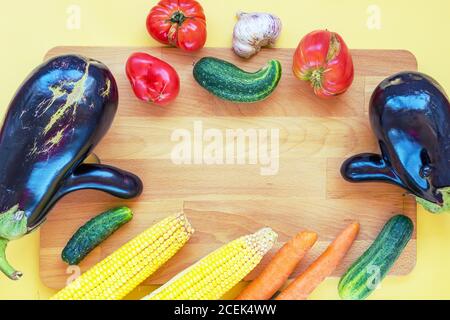 Verdure coltivate in casa, cibo brutto su tavola di legno, sfondo giallo, spazio copia Foto Stock