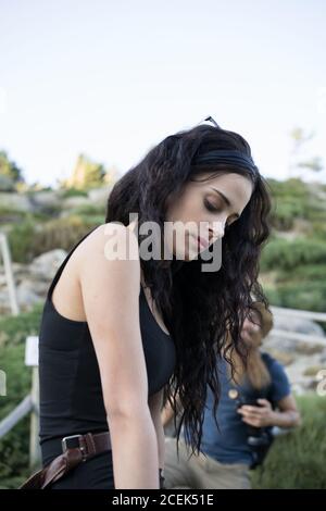Giovane donna seduta su recinto e sorridente Foto Stock