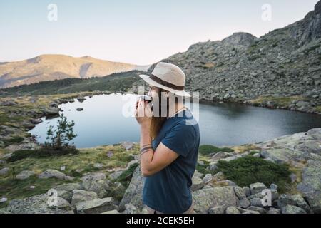Giovane uomo in piedi vicino al lago con coppa Foto Stock