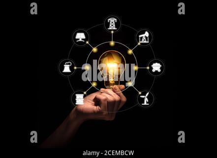 Lampada a mano con simbolo di riciclaggio all'interno contro con icone fonti di energia per lo sviluppo rinnovabile e sostenibile. Foto Stock